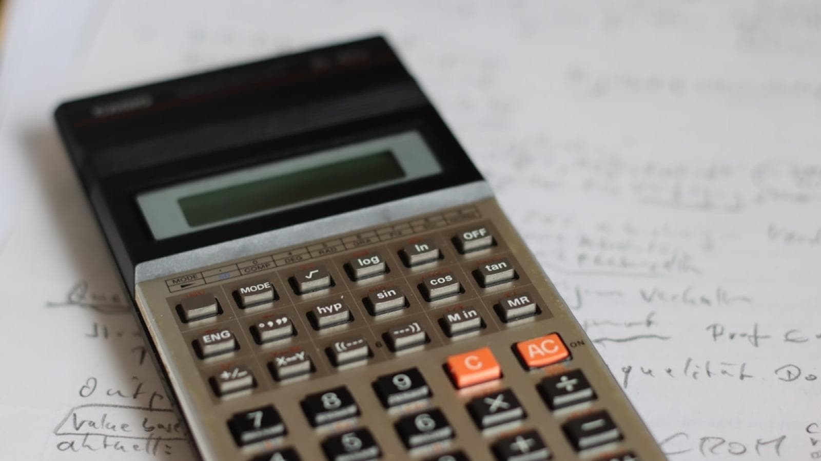 A scientific calculator resting on a page of handwritten working
