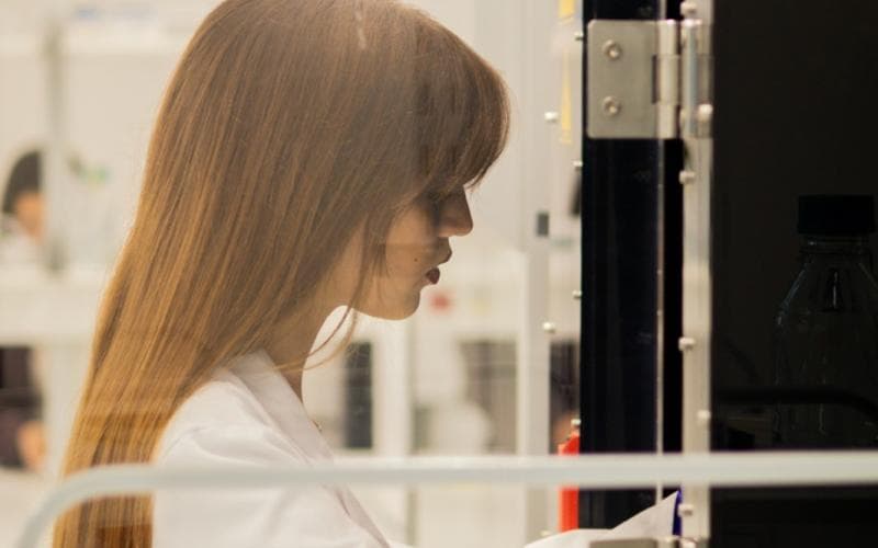 A laboratory scientist working at a bench in a clinical laboratory